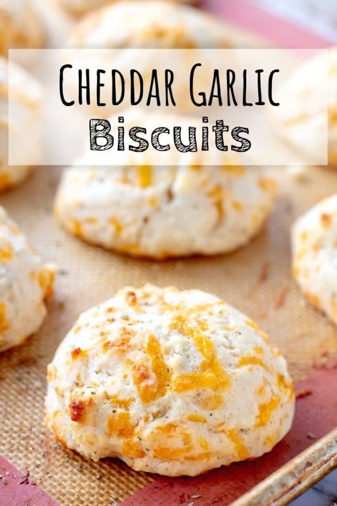 Baked Cheddar Garlic Biscuits on a baking mat with text overlay.
