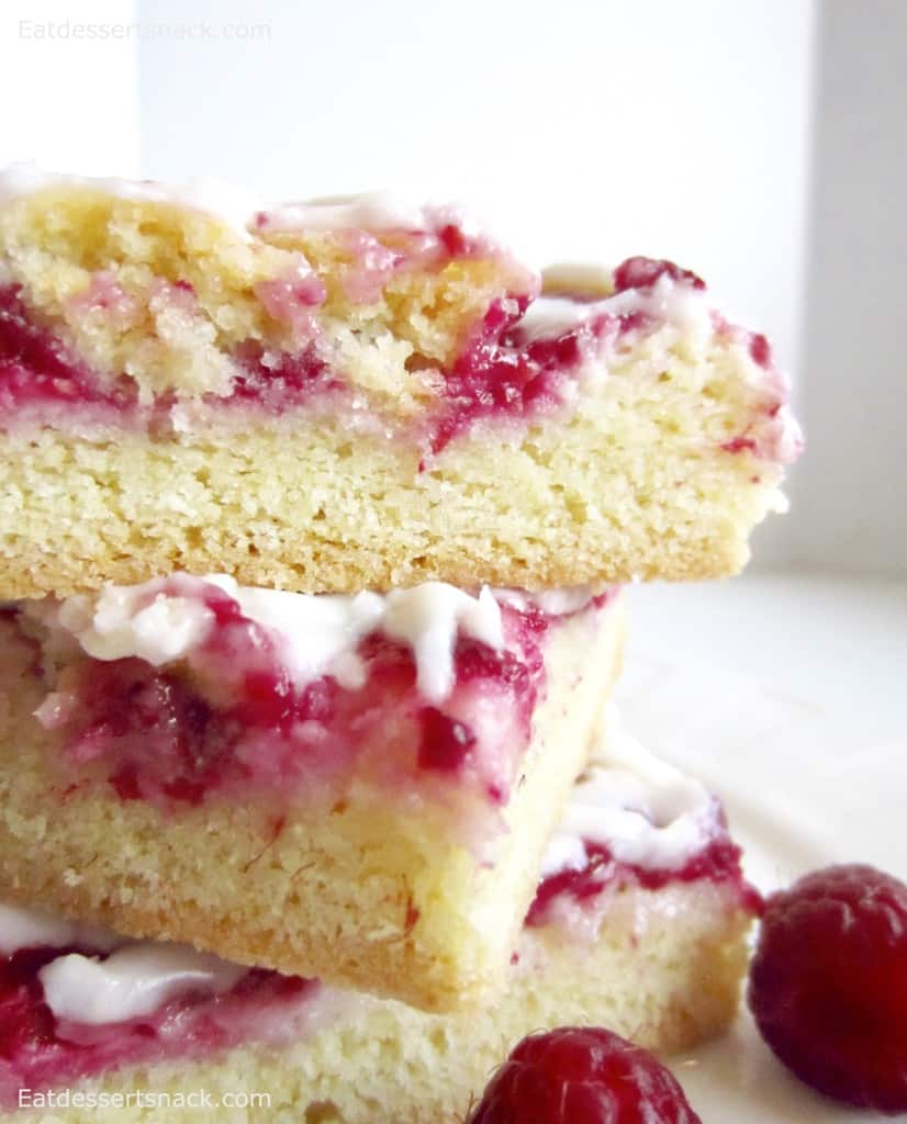 Three Raspberries and Cream Bars stacked on top of each other. 