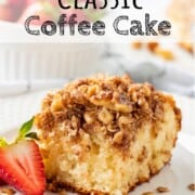 Slice of baked classic coffee cake on a white plate with strawberry.