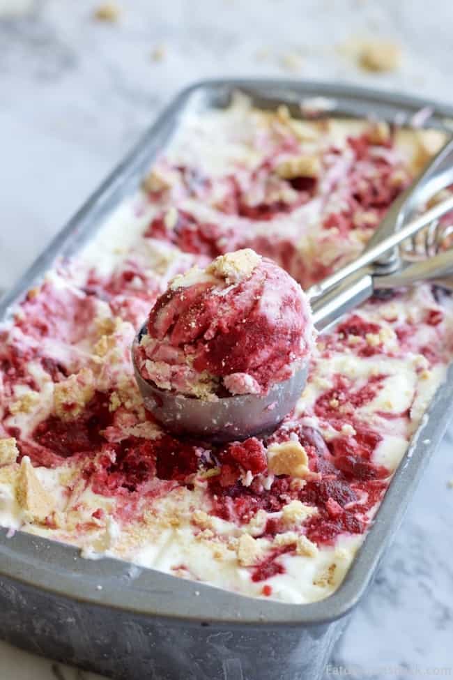 No churn cherry cheesecake ice cream in a scoop on a pan. 