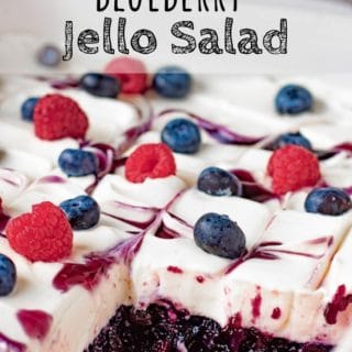sliced blueberry jello salad with whipped cream and berries on top.