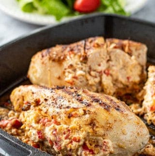 Cooked Pepperjack stuffed chicken breast in cast iron pan.