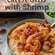 Cooked Cheesy Shrimp and Grits in gray bowl with bacon.
