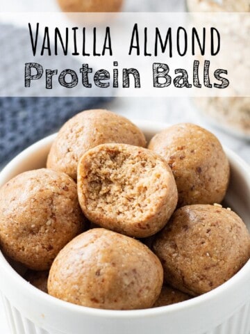 Almond Butter Protein Ball with bite mark in white bowl.