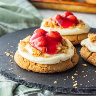Baked cherry cheesecake cookie on black plate.