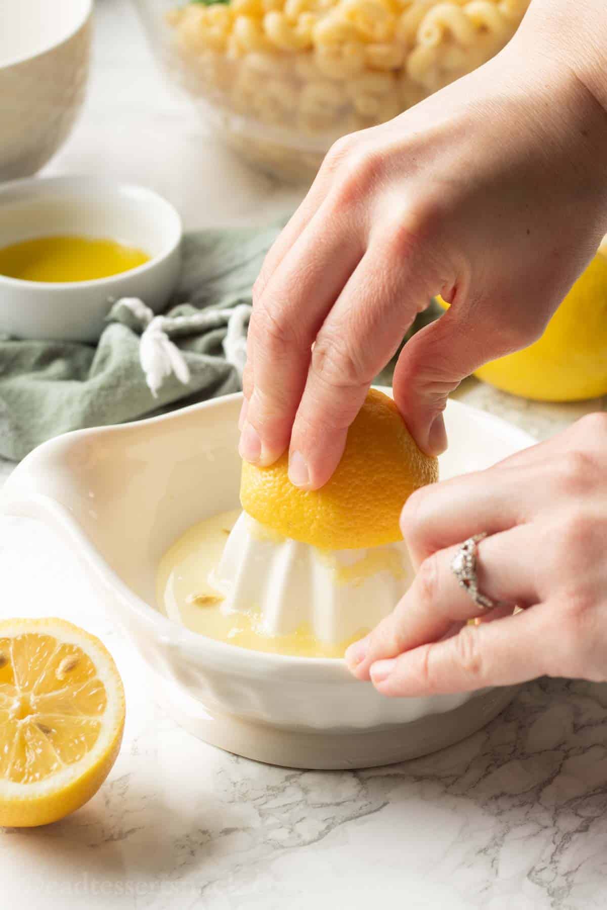 Squeezing lemon juice from lemon into white dish. 