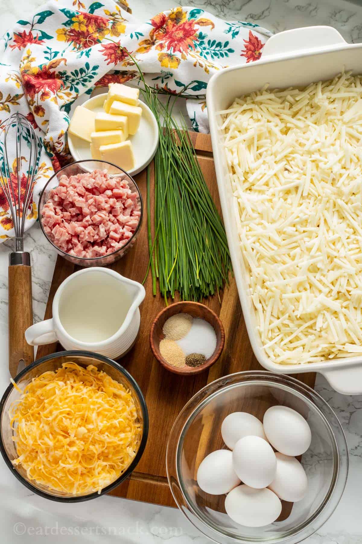 Ingredients for ham and cheese hash brown casserole on wood cutting board.