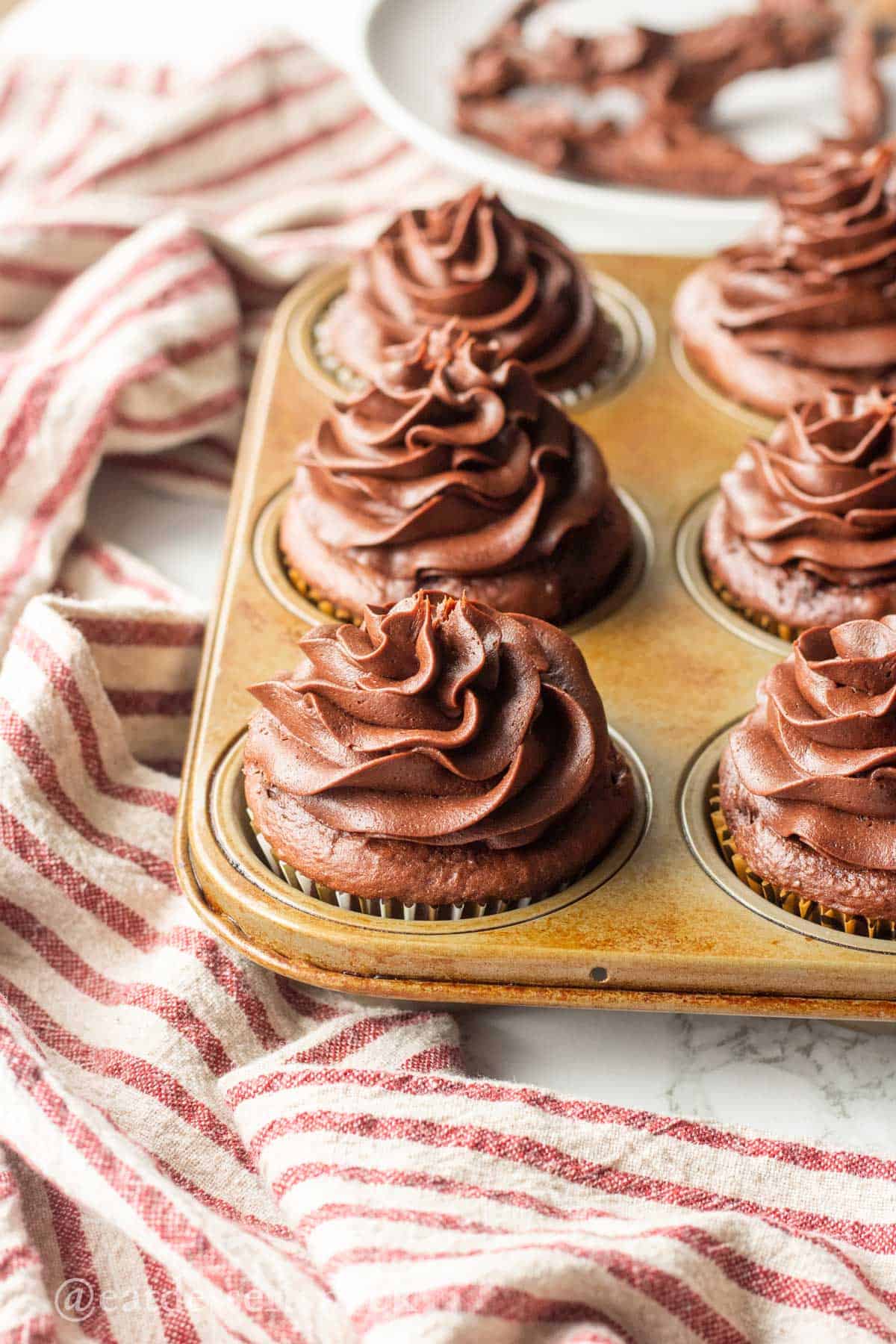 Chocolate frosted cupcakes in metal pan.