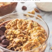 Glass bowl of chocolate peanut butter protein overnight oats with sliced banana and walnuts on top.