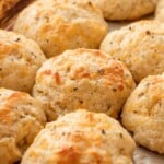 Baked cheddar garlic drop biscuits on metal pan.