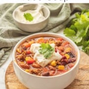 Cooked healthy taco soup in white bowl with sour cream and cilantro on top.