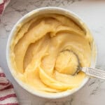 White bowl of honey butter with spoon.