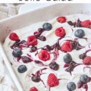 Blueberries and raspberries on whipped filling and blueberry jello in white dish.
