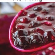 Cooked blueberry pie filling on spoon.