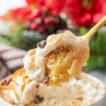 Bite of cooked christmas mug cake on golden spoon.
