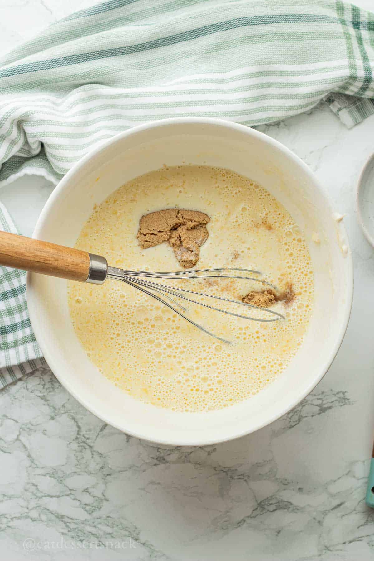 Brown sugar in wet ingredients in white bowl.