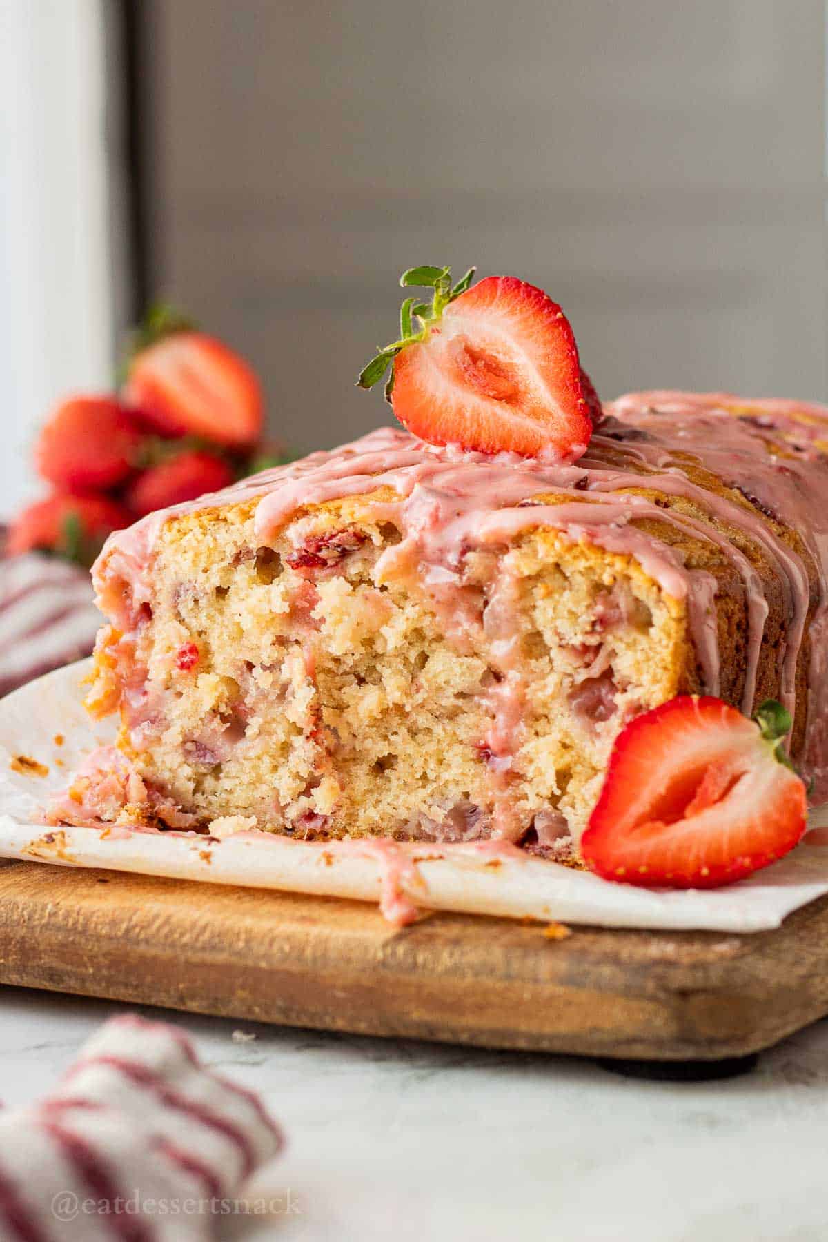 Sliced strawberry banana bread with icing.
