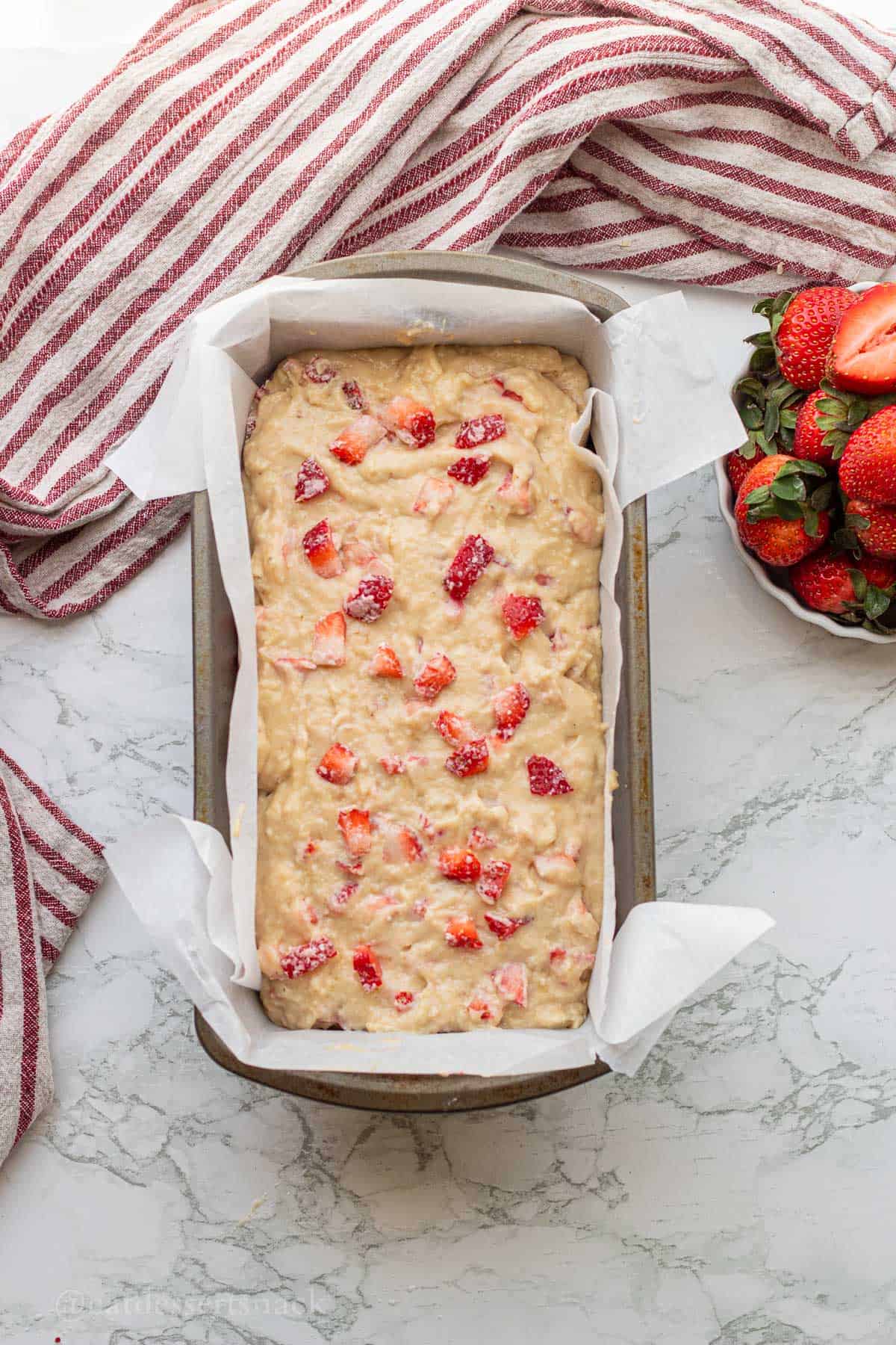 Raw strawberry banana bread batter in loaf pan.