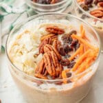 Pecans, raisins, carrots, and coconut on bowl of carrot cake overnight oats.