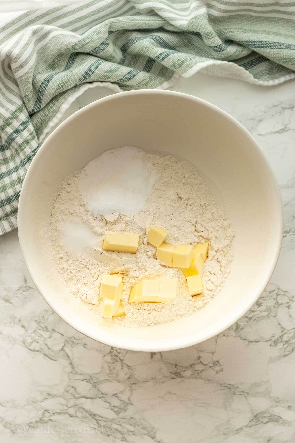 Butter in flour mixture in white bowl.