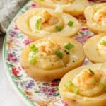 Filled deviled potatoes on floral plate.