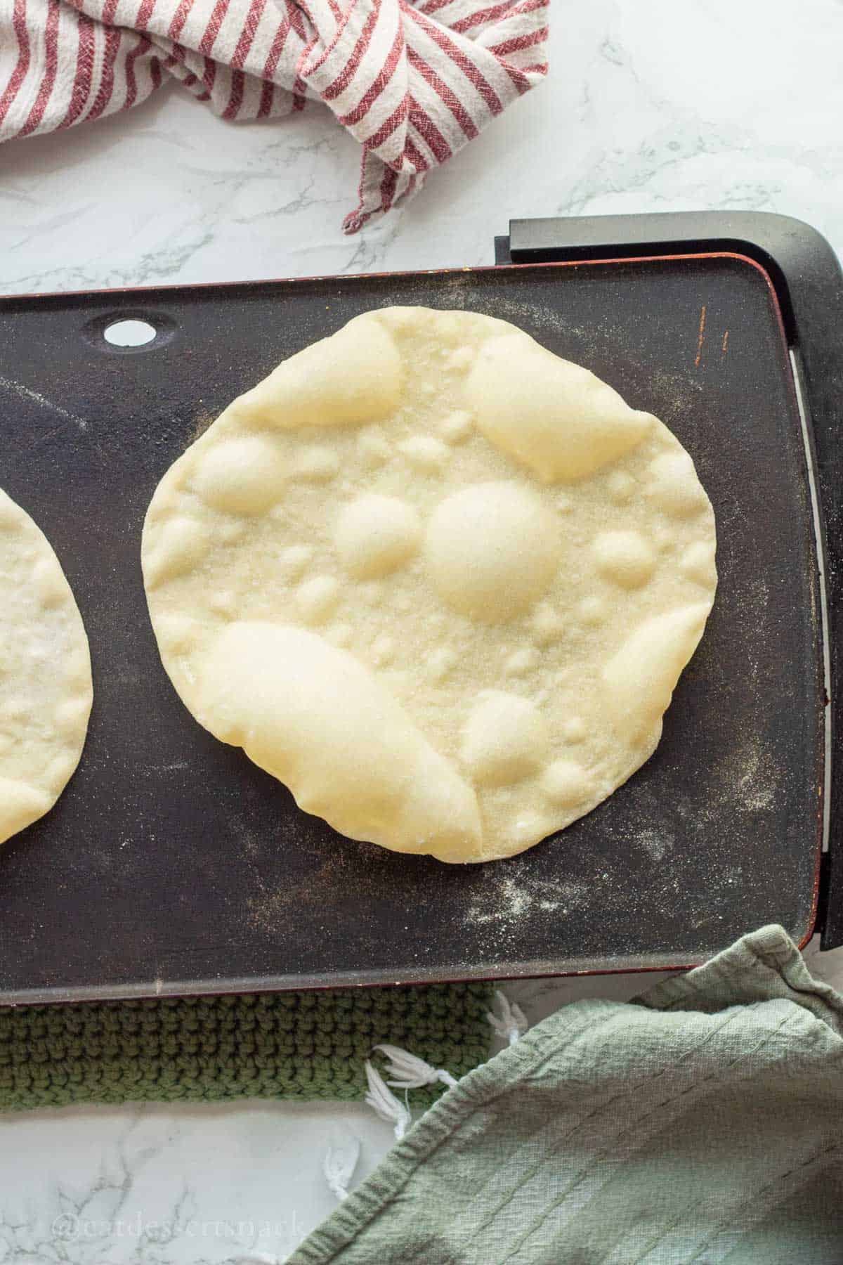 Cooking tortilla on griddle.