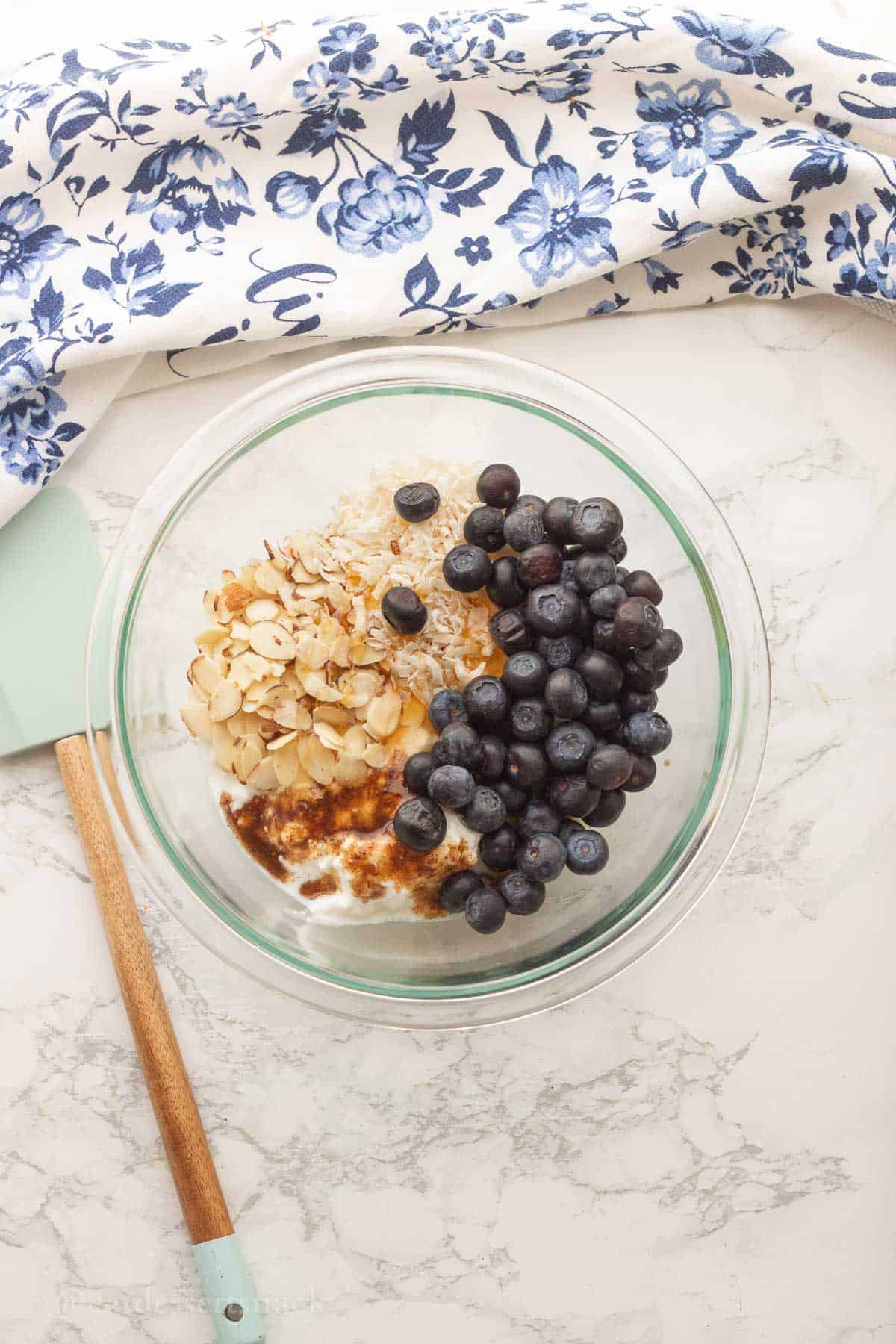 Blueberries, coconut, almonds, yogurt, and vanilla in bowl.