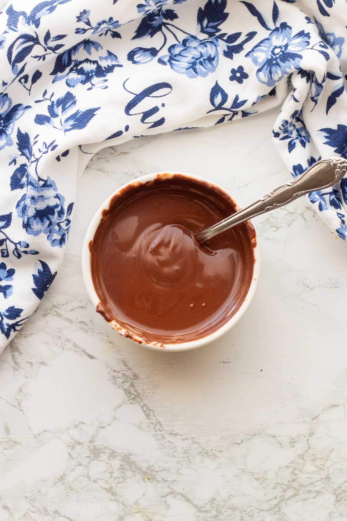 Melted chocolate in white bowl.