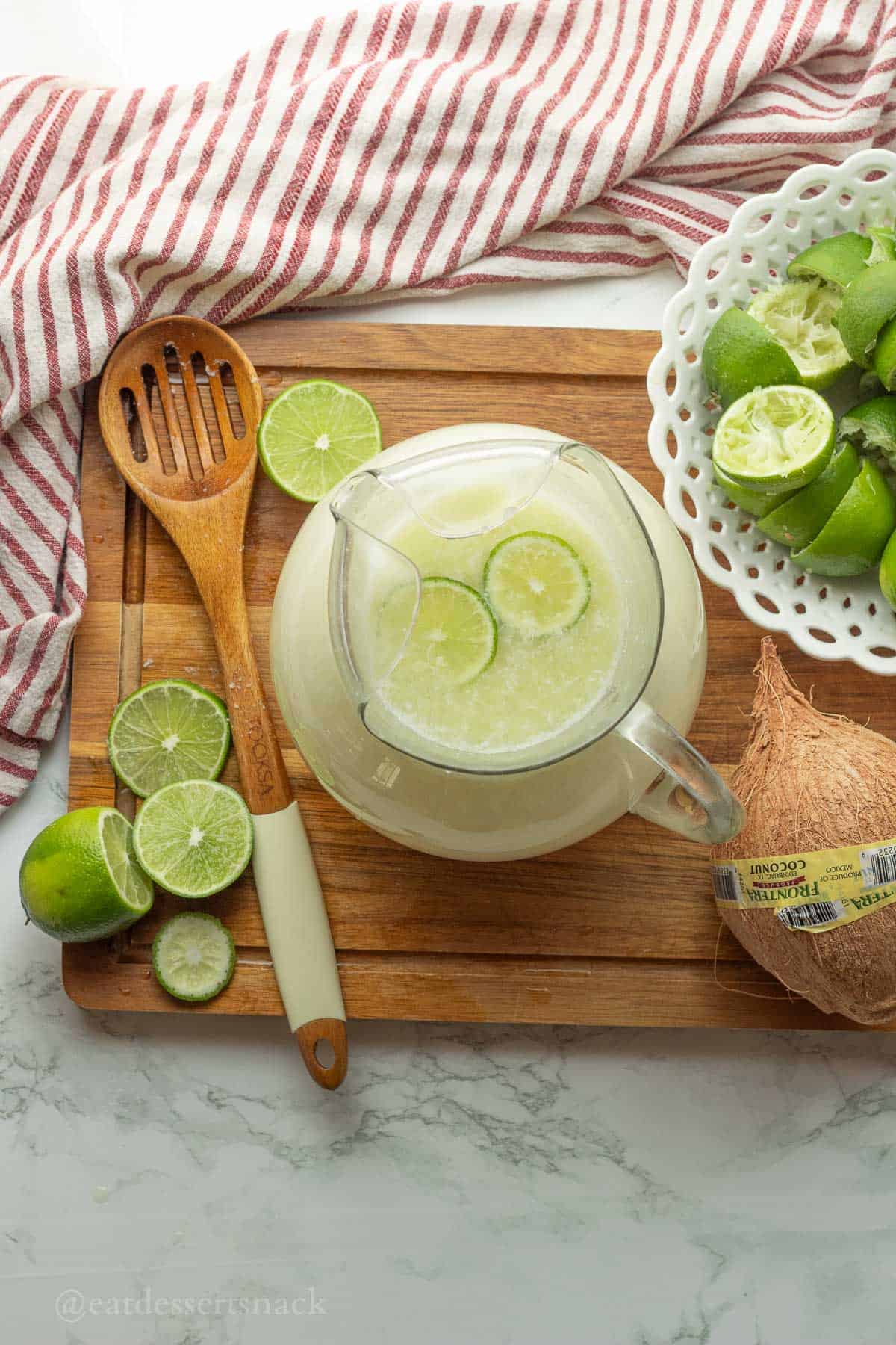 Pitcher of lime drink with lime slices.