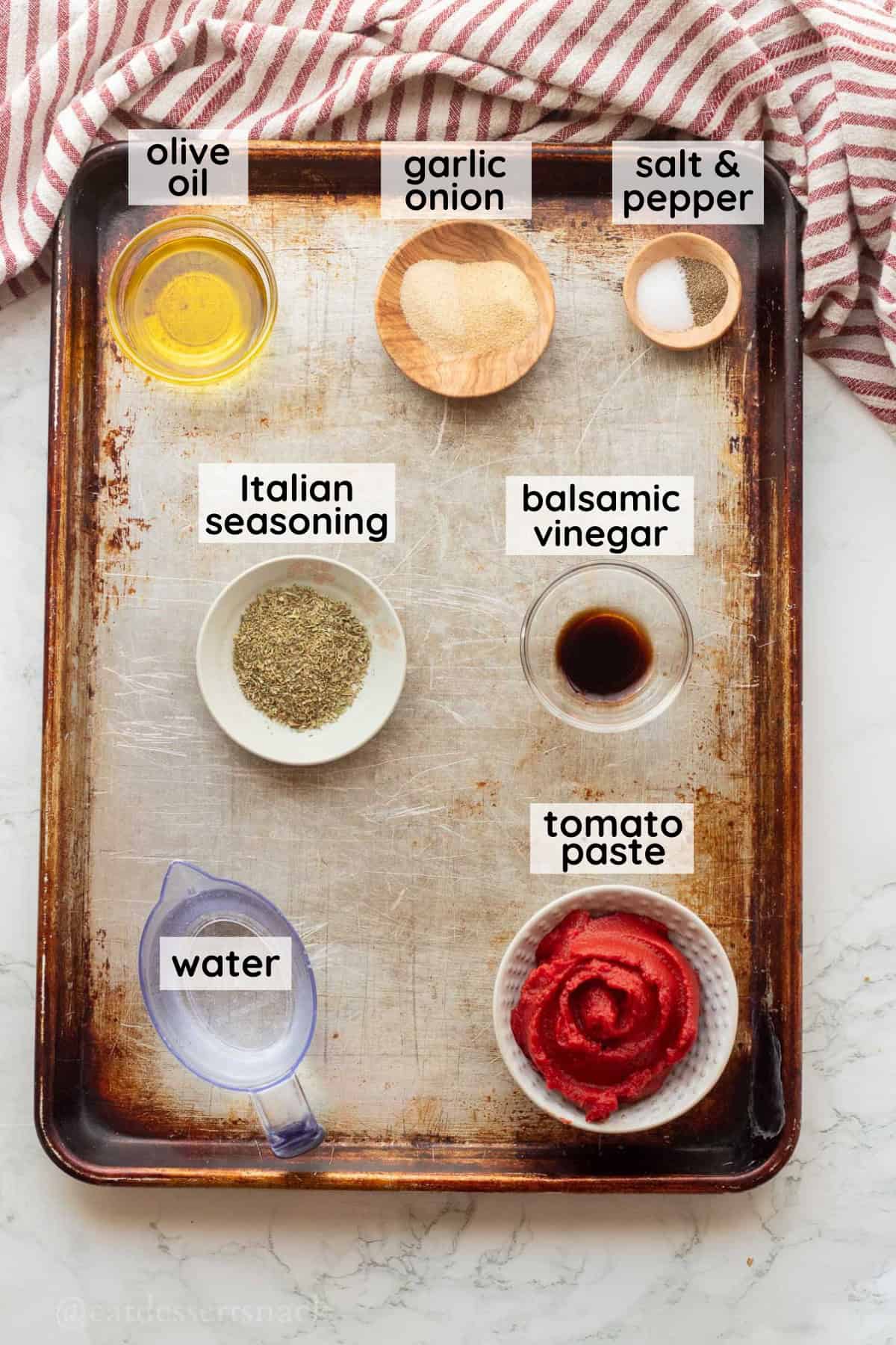 Ingredients for tomato paste pizza sauce labeled on metal pan.