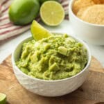Lime slice in bowl of guacamole.