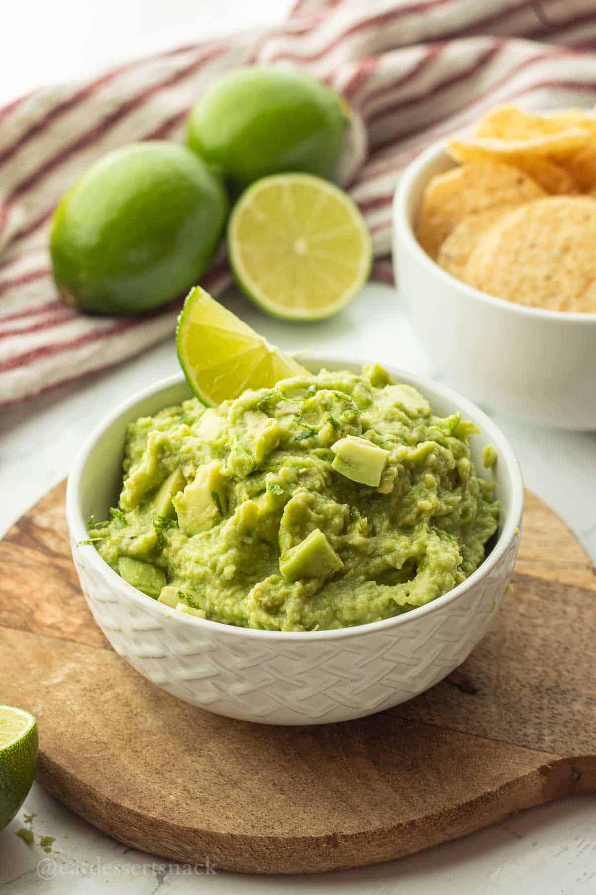 Lime slice in bowl of guacamole.
