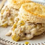Cooked biscuit and green chili gravy on a plate.