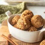 Rolled snickerdoodle protein balls in dish on cutting board.