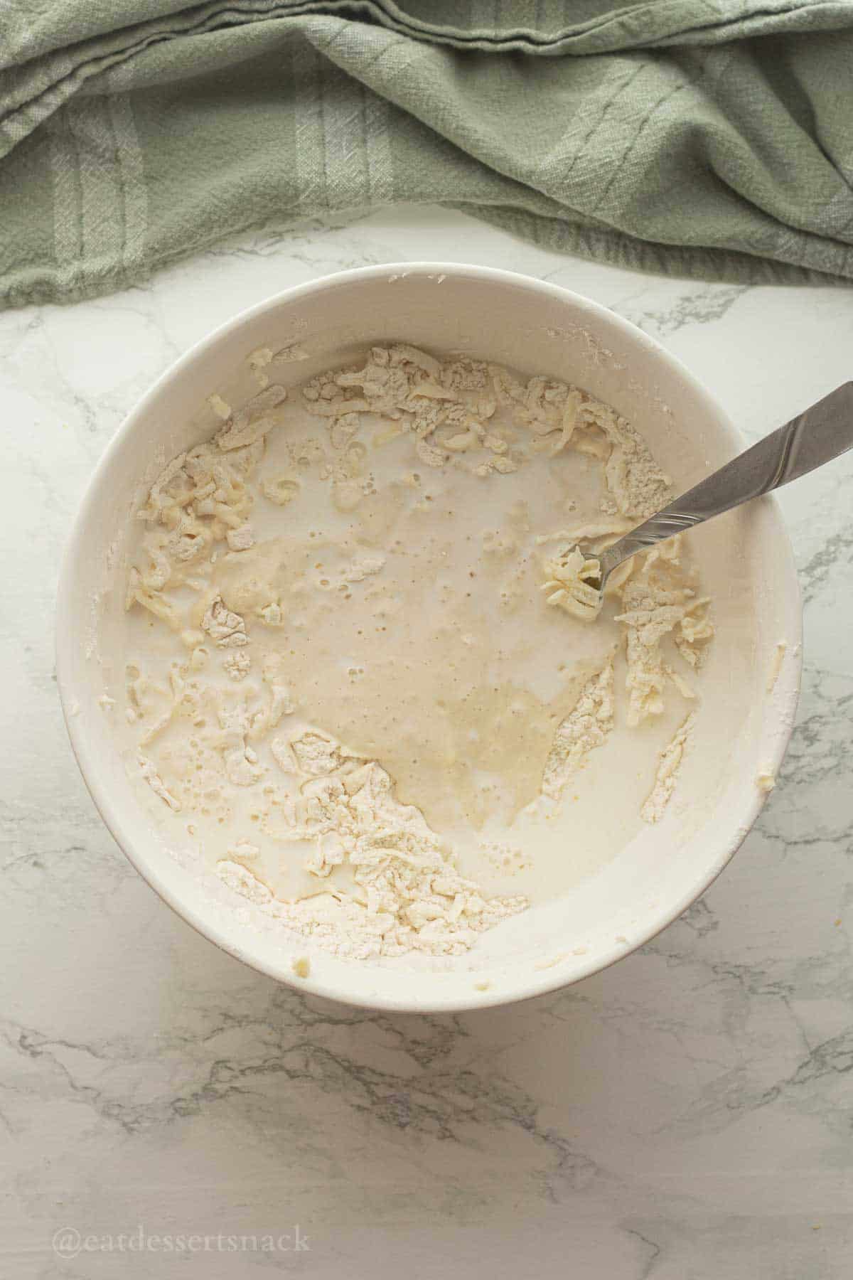 Sourdough discard and milk in biscuit dough bowl.