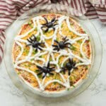 Spider olives on sour cream web on bean dip.