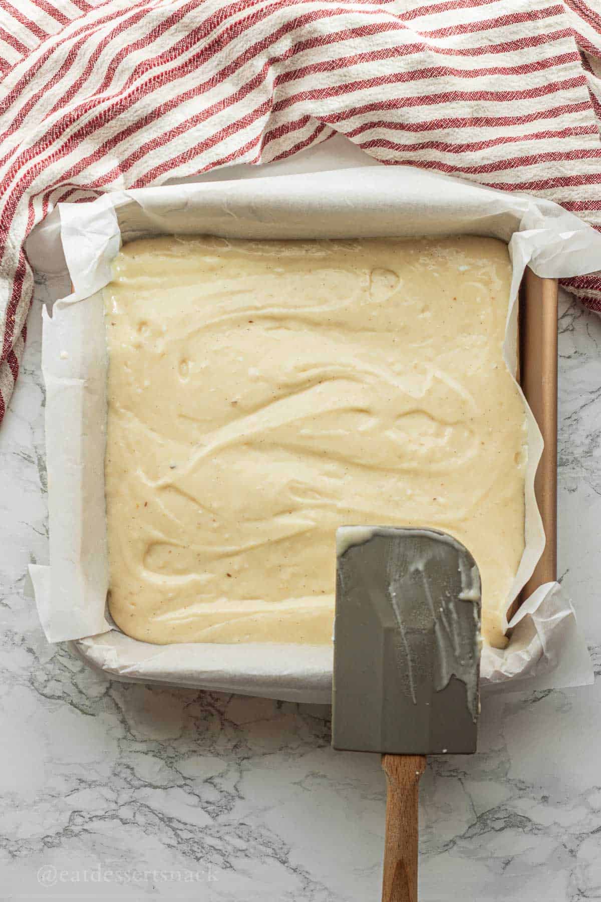 Raw coffee cake batter in pan with spatula.