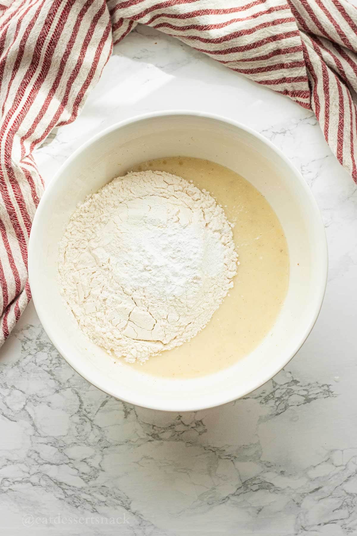 Flour, salt, and baking powder on we ingredients in bowl.