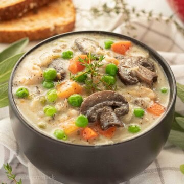 Bowl of creamy chicken wild rice soup with herbs.