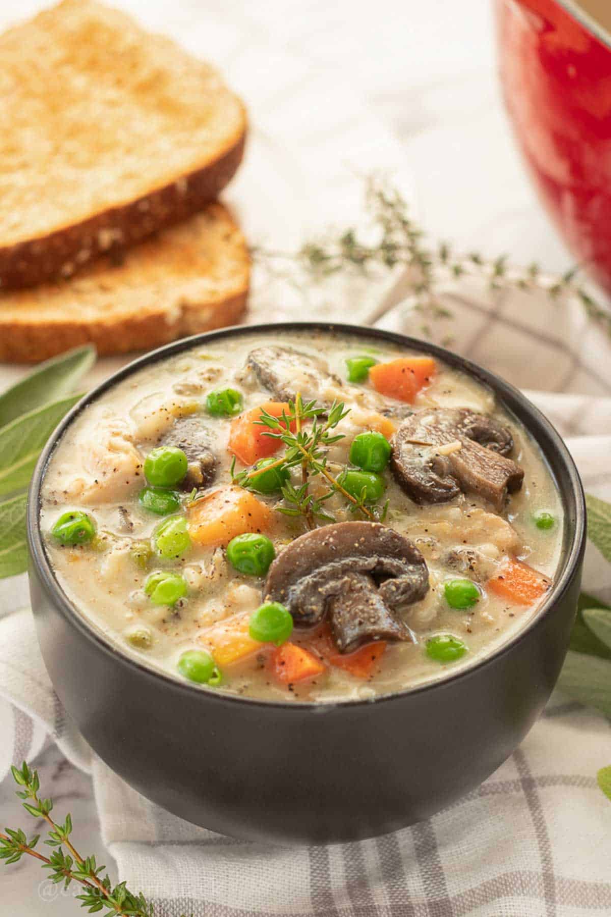 Bowl of creamy chicken wild rice soup with herbs.