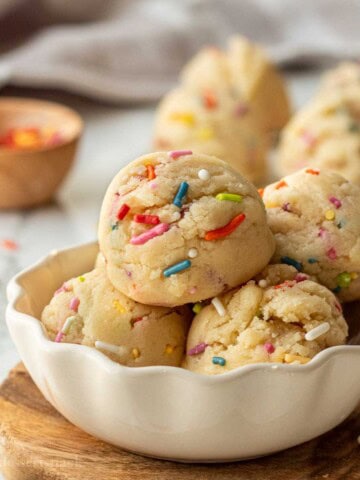 Scoops of edible sugar cookie dough in bowl with sprinkles.