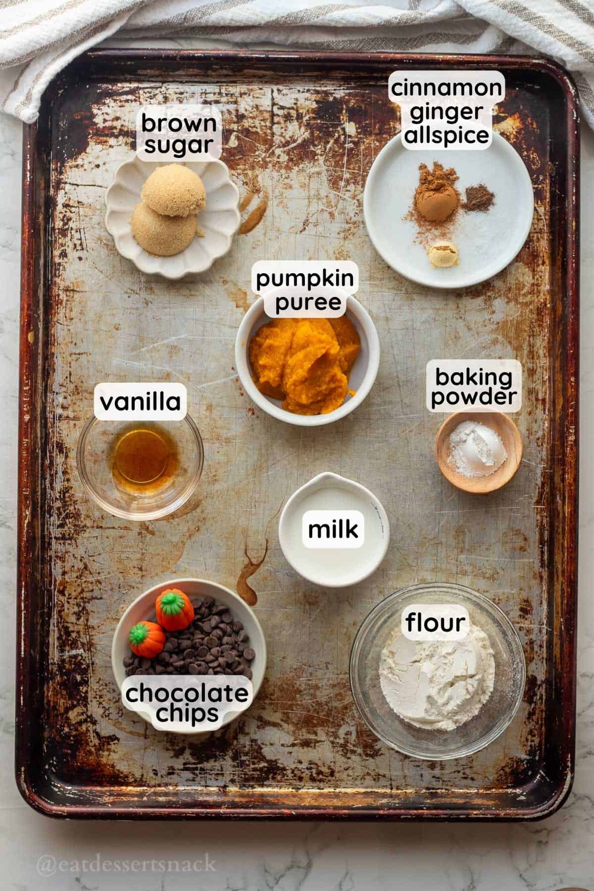 Ingredients for pumpkin mug cake labeled in glass bowls.