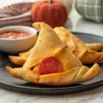 Baked witch had crescent roll on black plate.