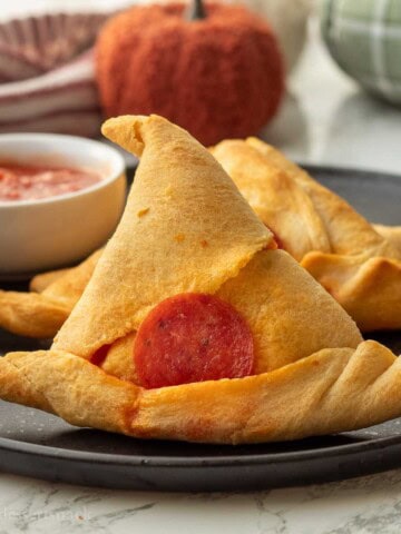 Baked witch had crescent roll on black plate.