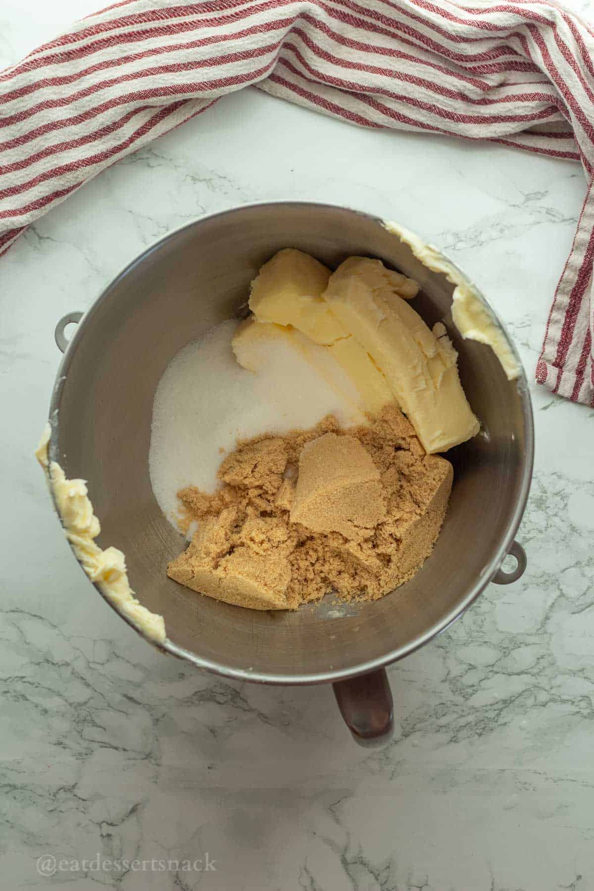 Butter, white sugar, and brown sugar in metal mixing bowl.