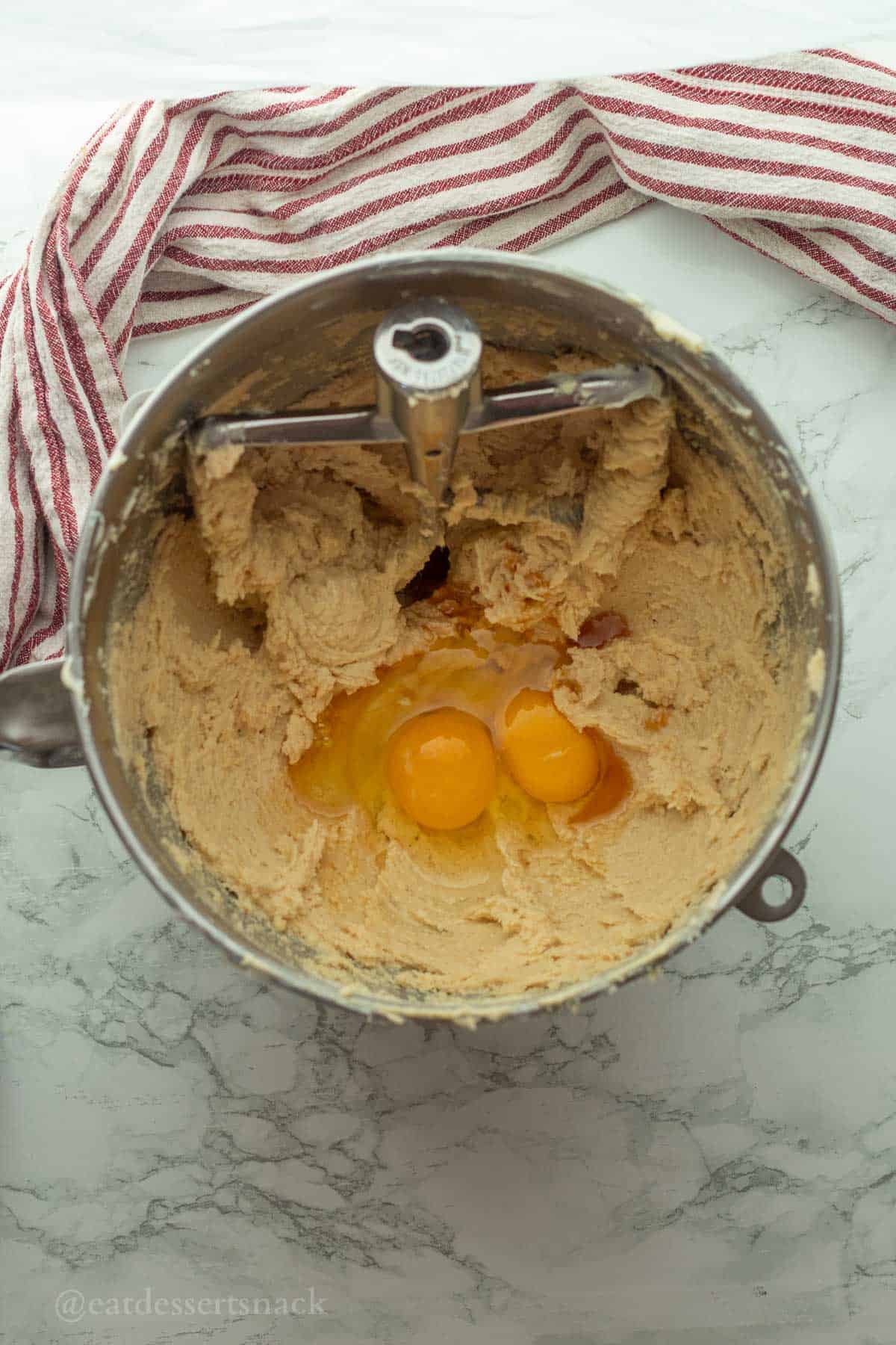 Eggs in vanilla pudding cookie dough in mixing bowl.