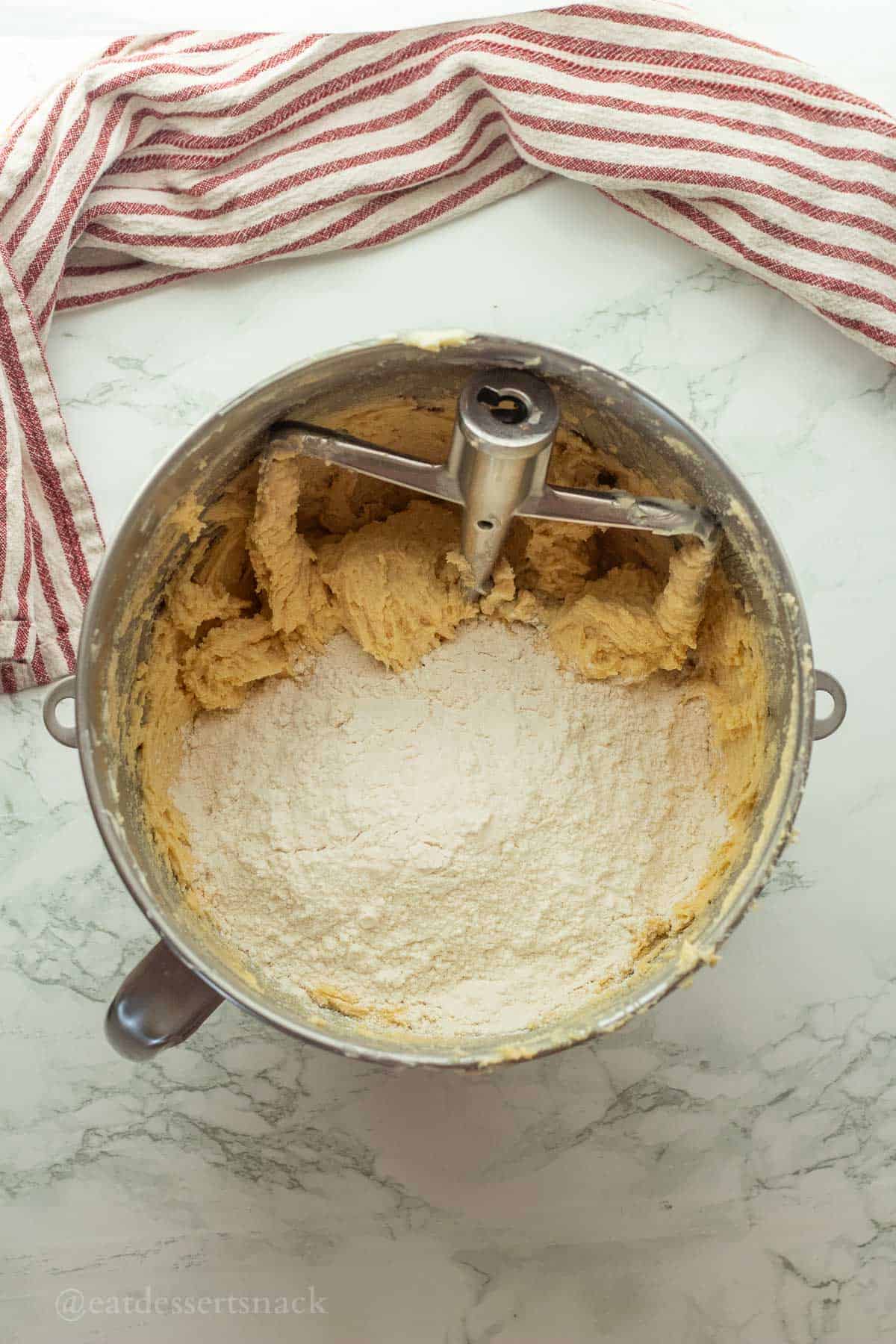 Flour in raw cookie dough in mixing bowl.