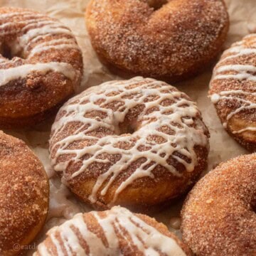 Glazed apple cider donuts on baking tray.