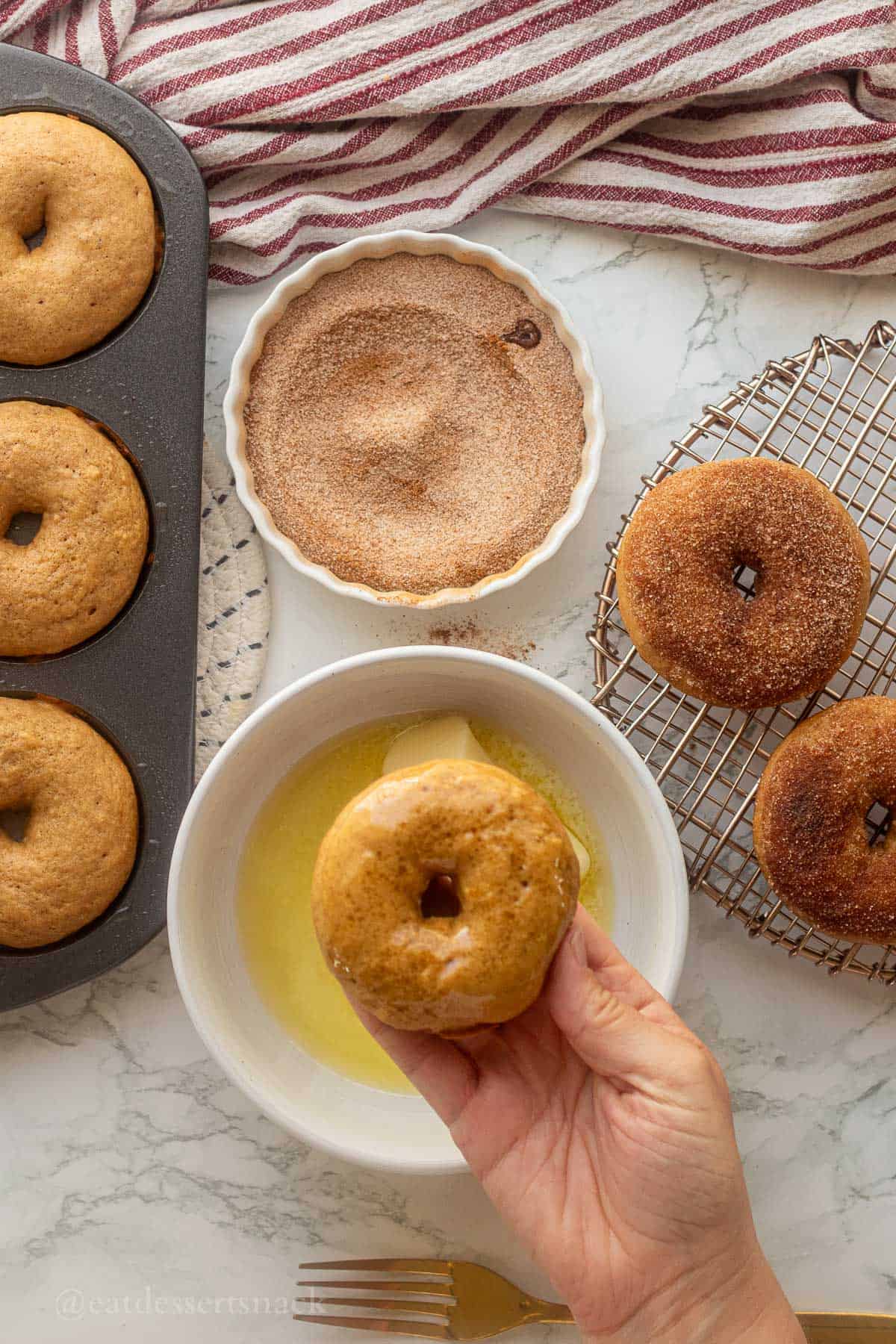 Dipping baked donuts in butter then cinnamon sugar.
