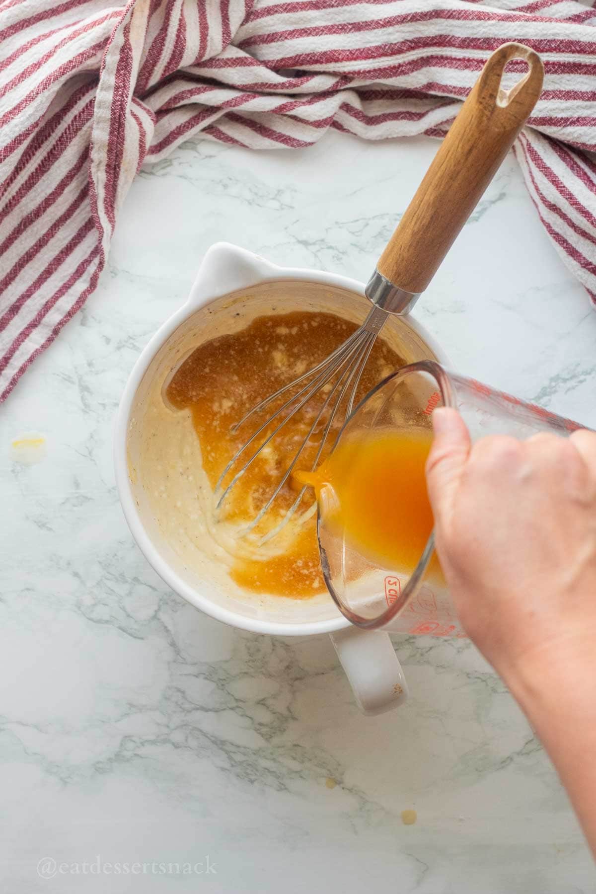 Pouring apple cider into measuring cup.
